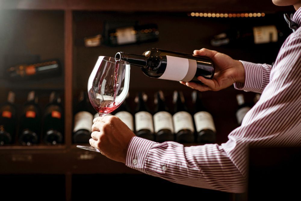 sommelier verse du vin dans un verre