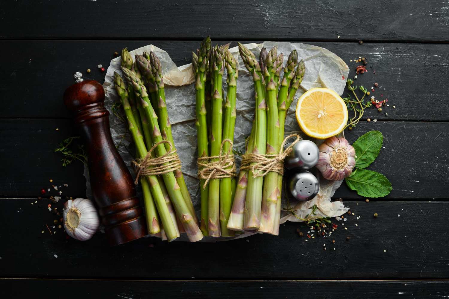 Asperges vertes fraîches sur fond de pierre noire, aliments sains, vue de dessus