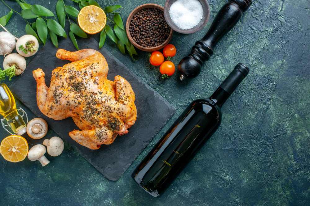 Vue du dessus d'un poulet épicé cuit et d'une bouteille de vin rouge