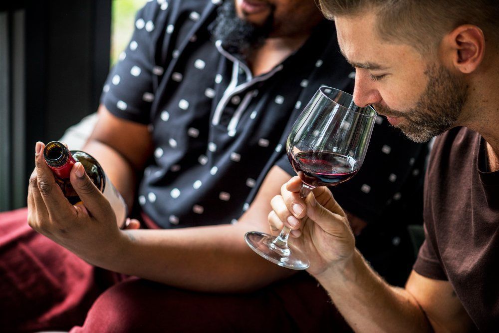 Homme dégustant du vin rouge avec des amis