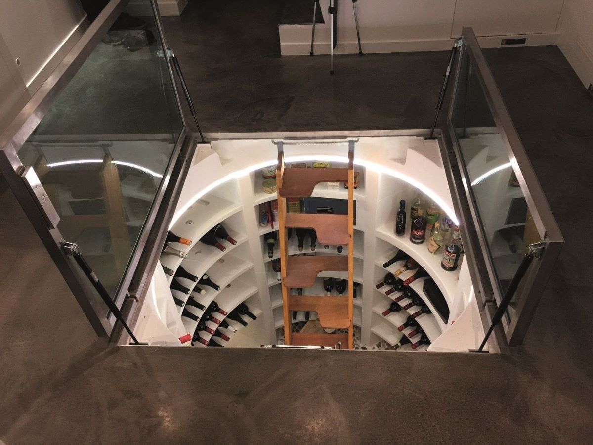 Cave à vin compacte préfabriquée ouverte et à trappe vitrée, en maison.